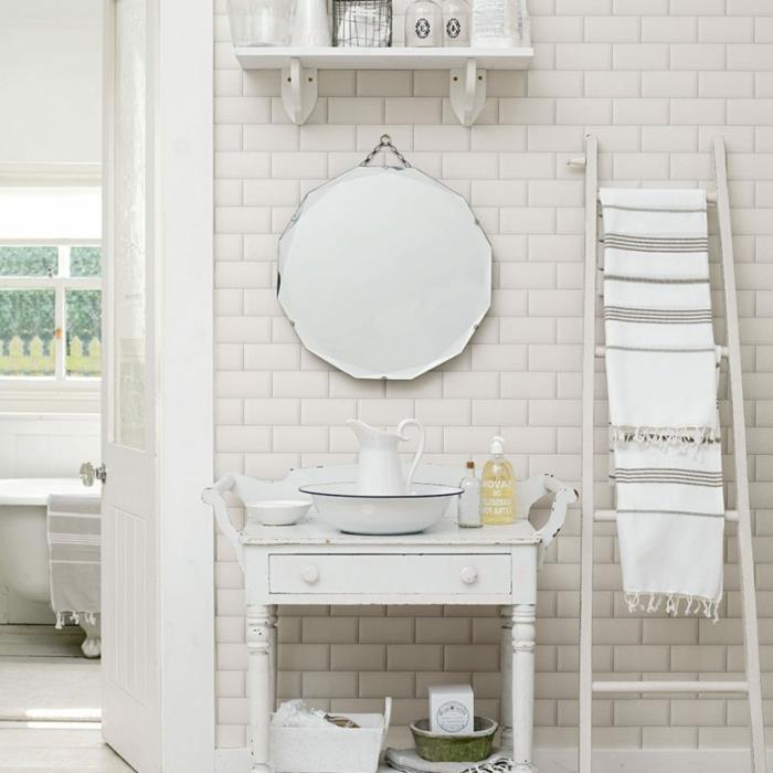 biela kúpeľňa, okrúhle zrkadlo, dlaždice metra, biely rebrík, polica z bieleho dreva, retro karafa a riad