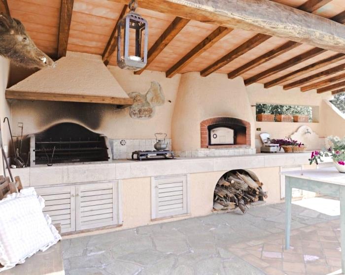 príklad krytej letnej kuchyne s masívnou strechou a veľkou kamennou podlahou, rustikálny a vidiecky dekor kuchyne