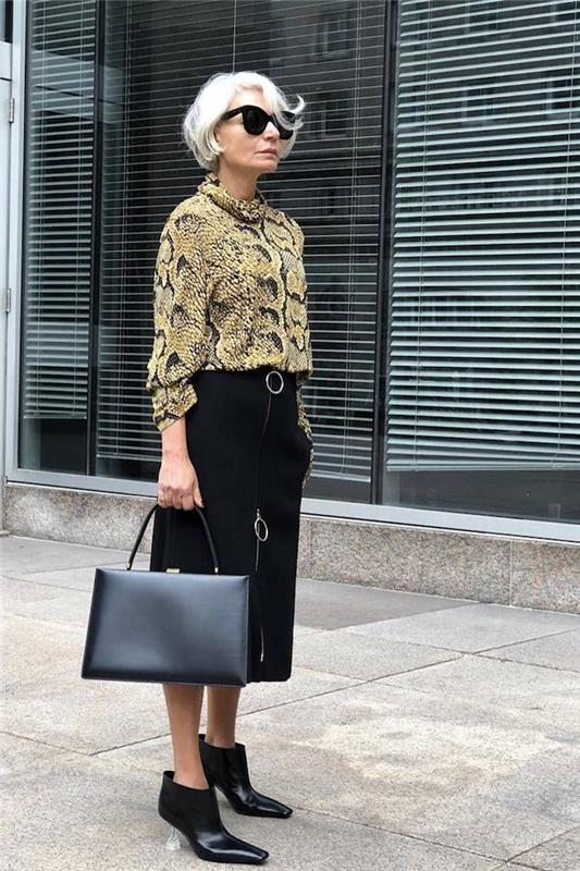 dámska košeľa so strednou dĺžkou a čiernou sukňou, kožená kabelka moderného vzhľadu, 60-ročná žena