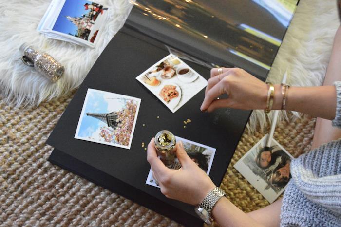 Svart kartongpapper, resefotografier i Paris, kvinna som sätter gnistrar runt fotona, scrapbookingalbum, hur man gör en scrapbooking själv