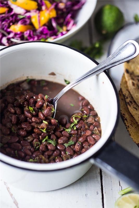 Ciotola con fagioli neri, cucchiaio con fagioli, cena tipica messicana, ingrediencia sul tavolo