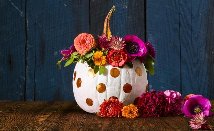 halloween pumpamodell, vit pumpa med gyllene prickar och blommor, rum med laminatgolv och mörkblå målade träväggar,