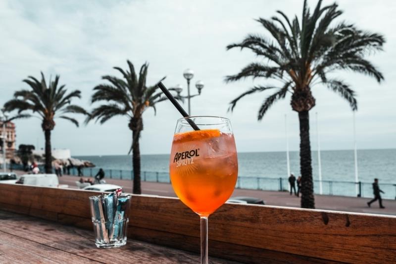 cocktail spritz lätt hemlagad förberedelse dryck strand sommar palmträd terrass trä