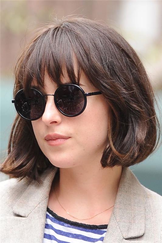 účes s krátkymi vlasmi so zúženými strapcami dakota johnson s okrúhlymi čiernymi slnečnými okuliarmi