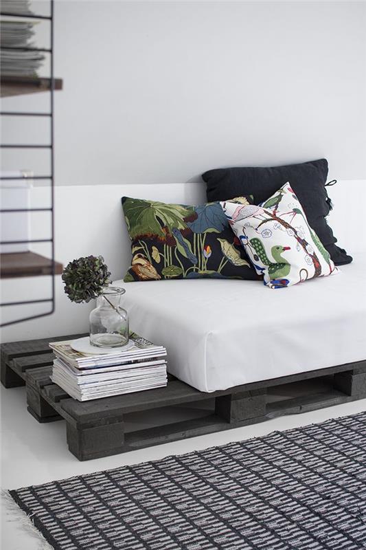 paletová pohovka prefarbená na sivú v príjemnom kontraste s bielym matracom a nezhodnými potlačenými vankúšmi
