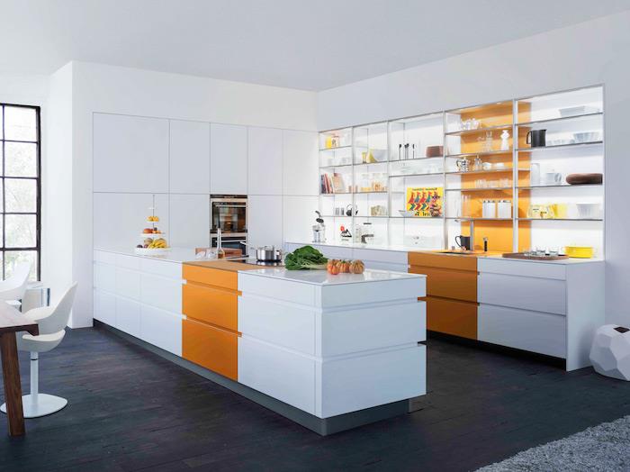 modernt vitt kök med inslag av orange färg, parkett i mörkt trä, öppna hyllor, matbord i brunt träbord och designerstolar