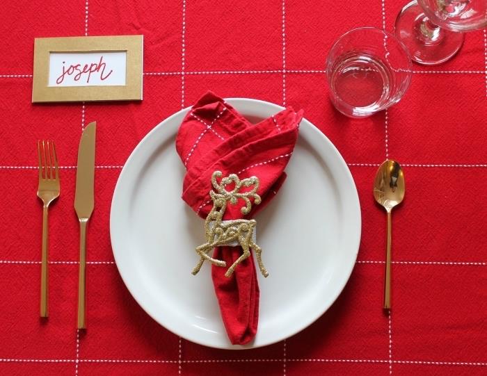 príklad skladania vianočných obrúskov, dekorácie stola s červeným obrusom a látkového obrúska zdobeného zlatým krúžkom na obrúsky