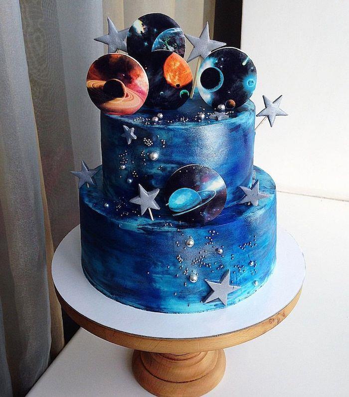 galaktický koláč so svetlo modrou a nočnou modrou zrkadlovou zmrzlinou so sivými hviezdičkami a dekoratívnym dekorom cukrových planét