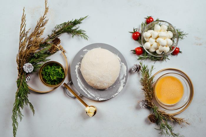 suroviny potrebné na výrobu vianočného chleba, cesta na pizzu, mini guličiek mozzarelly, rozšľahaného vajíčka, nasekaného koriandra, zmäknutého masla