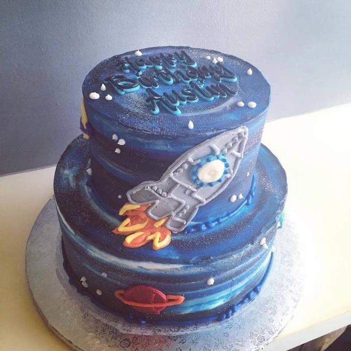 model narodeninovej torty pre chlapčeka, fialová, modro -biela poleva s krémovým krémom, dizajn rakety a maslovej smotany