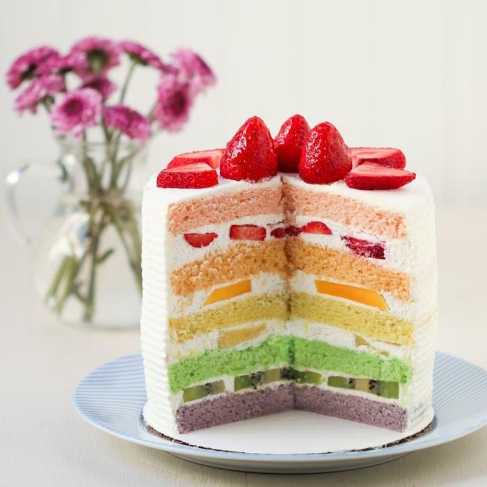 magisk tårtidé bestående av sockerkaka i olika färger med fruktbitar mellan lagren