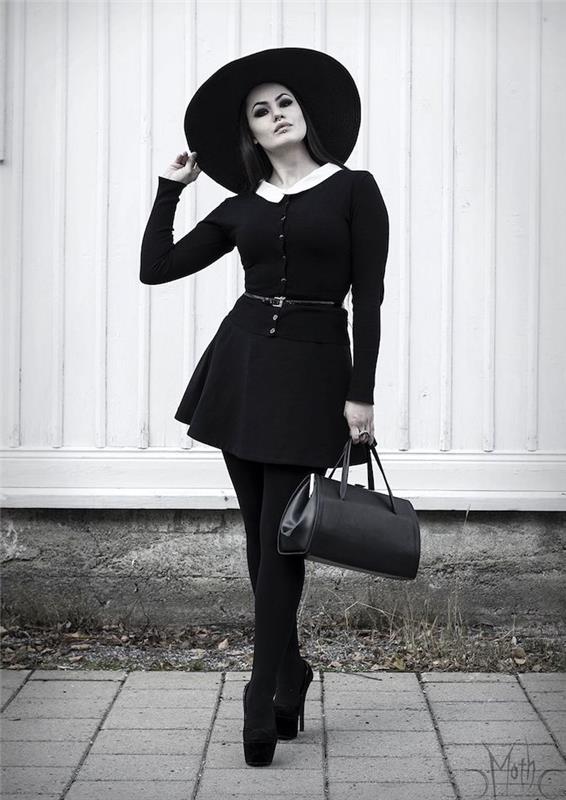 enkel kvinna halloween kostym i svart klänning med vit flygning och svarta fotstövlar, svart hatt och svartvitt smink