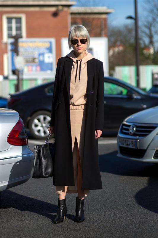 akú farbu má khaki béžová, elegantný ležérny outfit s kapucňou, prednou rozparkovou sukňou a dlhým čiernym kabátom