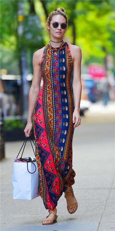 en lång tryckt klänning med etniska mönster, remmar runt halsen, etnisk chic på sommaren