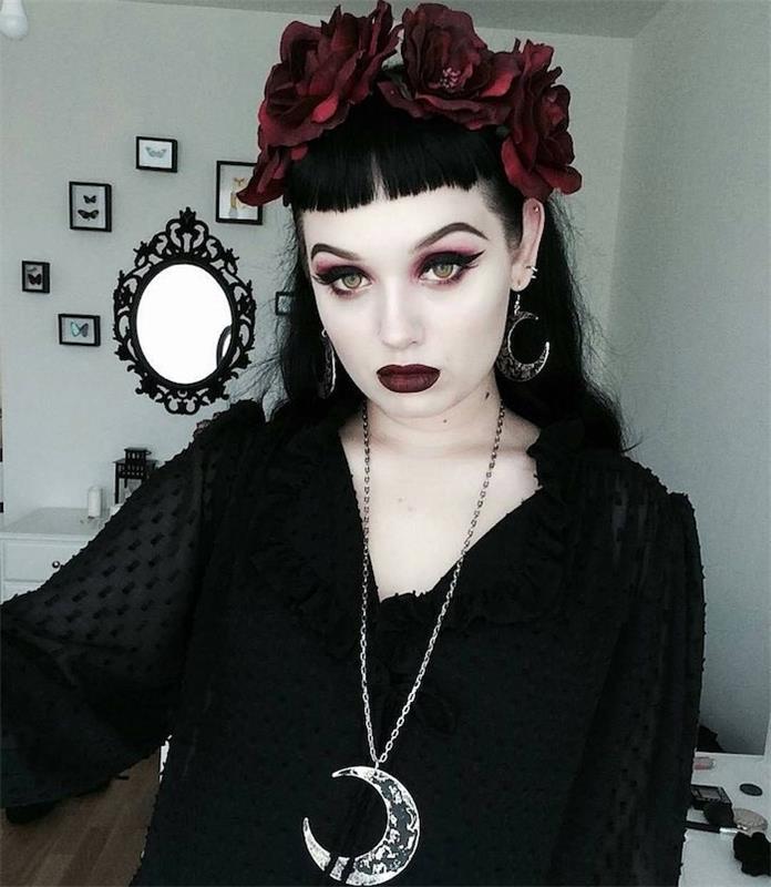 häxmakeup i gotisk stil, svart eyeliner, rosa ögonskuggor, mörkt vinrött läppstift, svart skjorta och mörk röd blomkrona