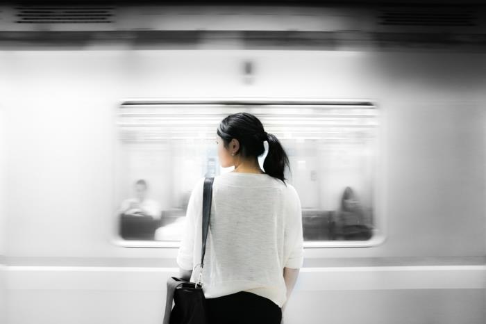 reser med kollektivtrafik, ung flicka framför tunnelbanan, flicka med vit t -shirt, svarta byxor