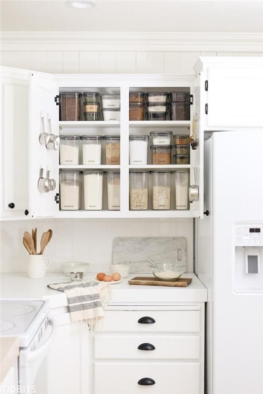 úložný priestor v kuchynskej skrini so vzduchotesnými boxmi na ukladanie potravín a háčikmi pripevnenými k dverám skrine
