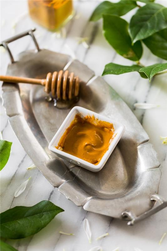 Hemmagjord renande mask med honung, kanel och gurkmeja, naturlig kosmetisk produkt för klar och strålande hud