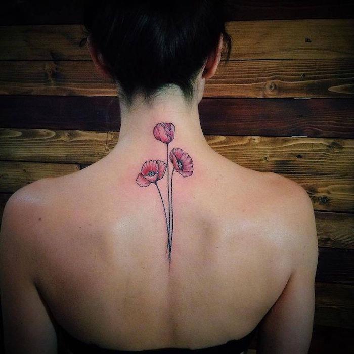 rosa vallmo tatuering på kvinnans rygg och hals