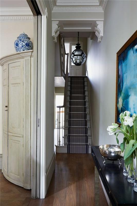 corridoio-pavimento-parkett-legno-colore-scuro-skala-mobil-decorazione-dipinto-vasi-fiori