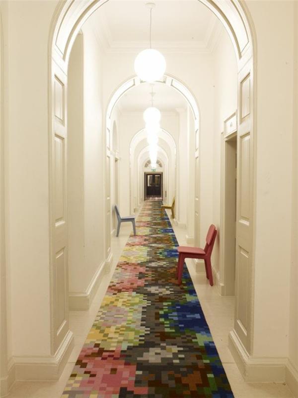corridoio-stretto-lungo-pavimento-tappeto-colorato-sedie-plastica-porte-soffitto-arca-lampadari-sospensione