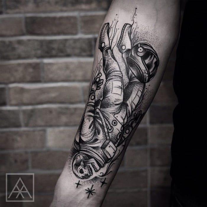 astronautskelett tatuerat på armen på en man, tatppmodell med original symbolvärde