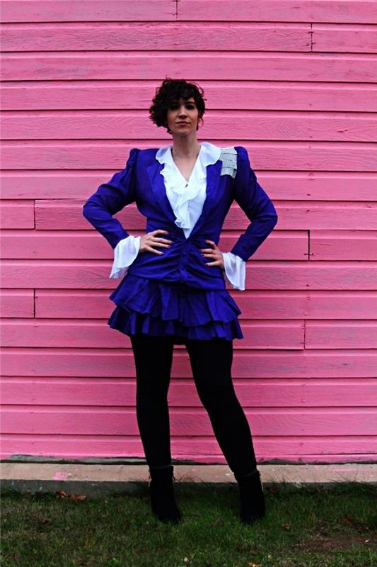 Kostým 80. rokov sa skladá z bundy, bielej košele s volánmi, purpurovej volánovej sukne a čiernych legín