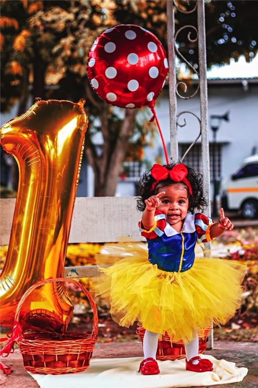 snövit födelsedagsdräkt, folienummerballong och prickig mylarballong för en första födelsedagsfotografering
