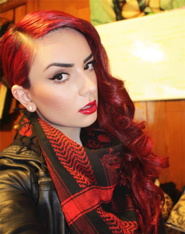 retro farbené kučeravé červené vlasy s líčením čiernej a rúžovej očnej linky a červeno -čiernym šálom keffiyeh