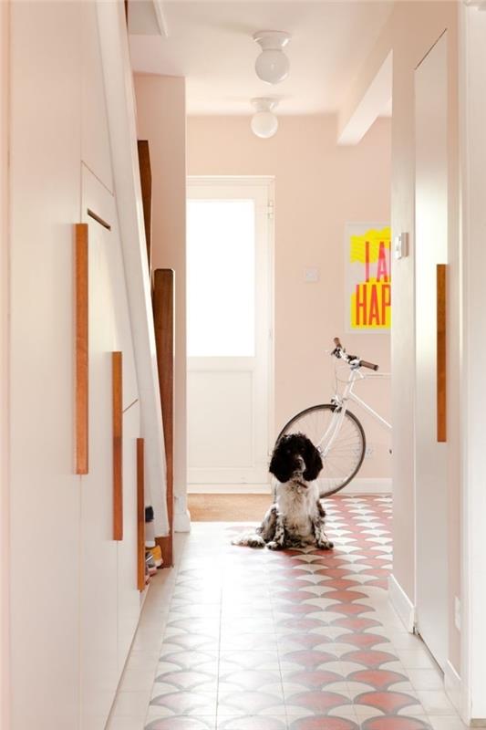 hall deco målad i en delikat nyans av rosa livas upp av några inslag av terrakotta och gult genom plattorna och den lilla inredningen