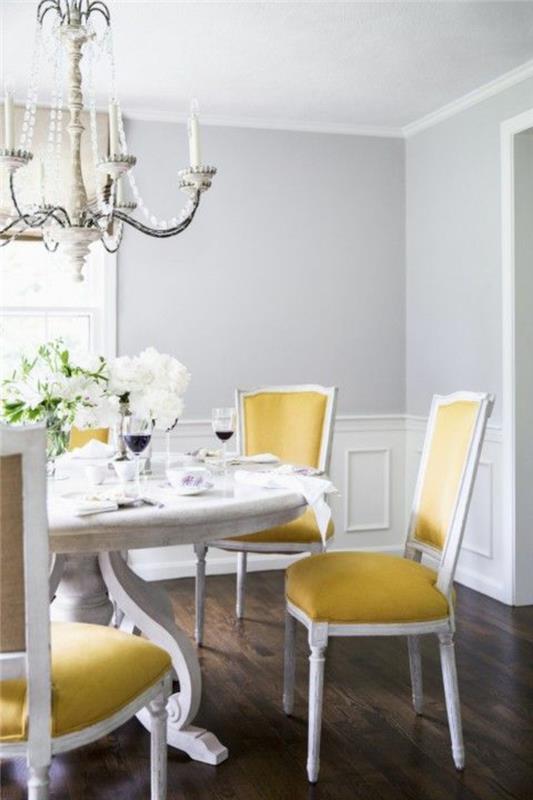 perlovo sivá v jedálni s veľkým klasickým barokovým lustrom a žltými a bielymi stoličkami