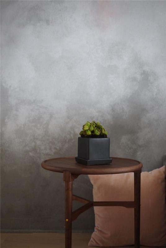 trendová stena s betónovou textúrou, dekorácia obývačky s betónovými sivými stenami s hnedým dreveným konferenčným stolíkom