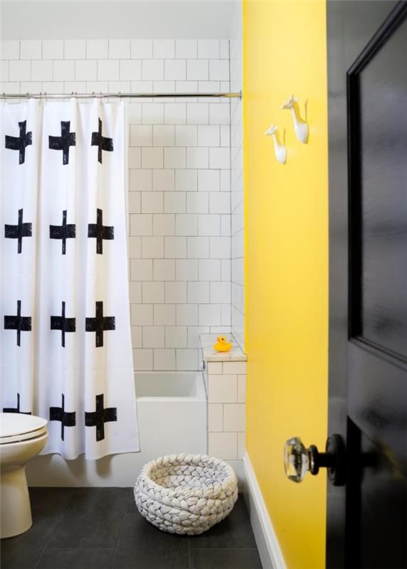 modernt badrum i vitt och nori med del av väggen i gult, litet badrumsinredningsidé för barn