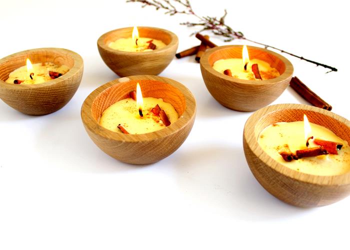 كيفية صنع الشموع ، شمع الشموع في أكواب خشبية صغيرة بداخلها أعواد القرفة