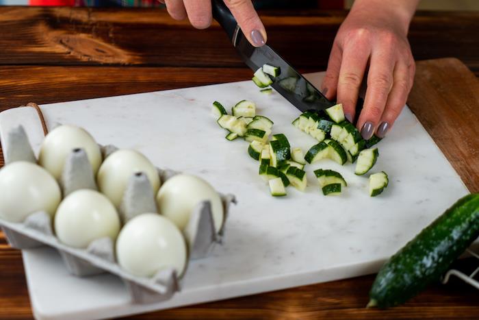 tärna en gurka för att göra en påskrätt, snabbt och enkelt äggmimosa recept