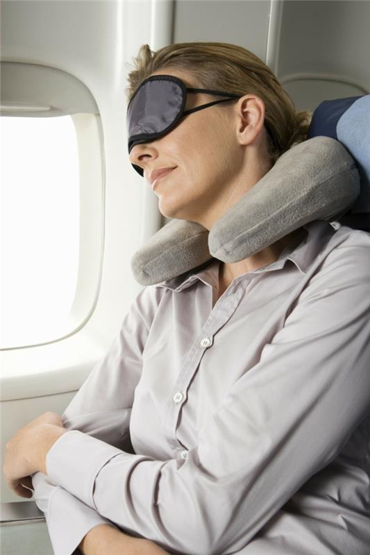 Žena spiaca v lietadle s maskou na oči