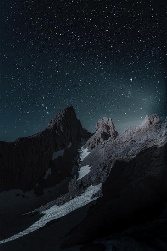 خلفية داكنة جميلة مع موقع طبيعي ، صورة لقمم الجبال تحت سماء الليل المنقطة بالنجوم