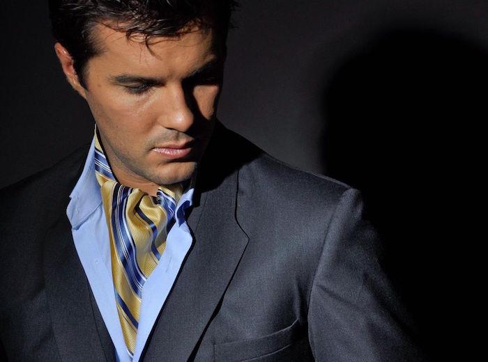 modellfoto av guld- och blå ascot- eller lavallière -slips på ljus skjorta och grå kostym