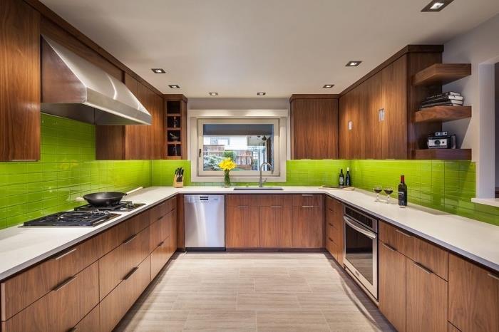 تصميم داخلي حديث في مطبخ بجدران بيضاء ومجهز بأثاث من الخشب الداكن ويانسون أخضر