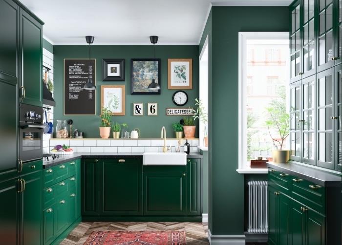 تصميم مطبخ حديث بجدران مطلية باللون الأخضر الزمردي مع بلاط أبيض وأثاث أخضر داكن