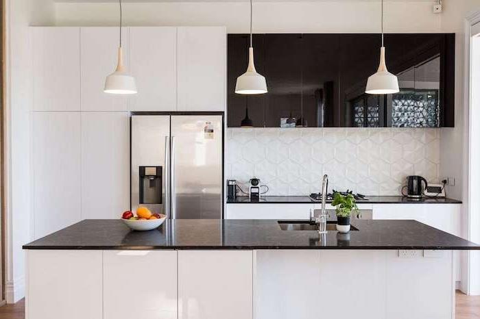 modernt vitt och svart kök, vitt kök backsplash med geometriska mönster 3 d effekt, svart bänkskiva och väggar, brun parkett, vita taklampor