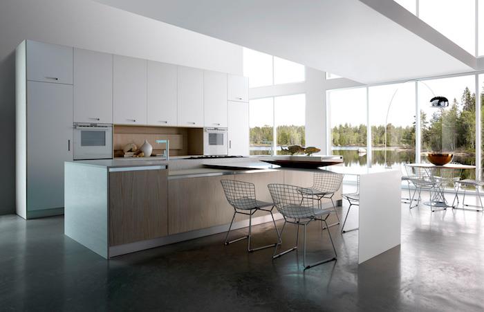 utrustat kök med vita möbler och backsplash av trä, central ö i vitt och trä, kolgrått golv, metallstolar, stora fönster