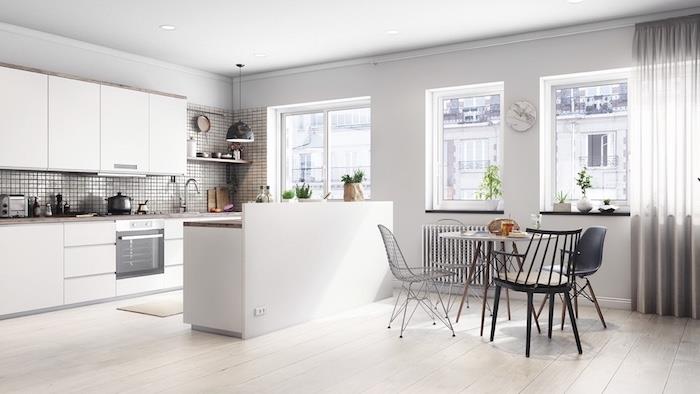 exempel på modernt kökstänk, ljus parkett, köksskåp och vit centralö, liten matplats runt bord och designerstolar i skandinavisk stil