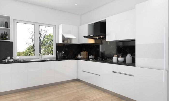 مطبخ أبيض مع سطح عمل وغطاء خلفي مطلي باللك الأسود ، وباركيه فاتح ، وجدران بيضاء ، وتصميم مطبخ حديث