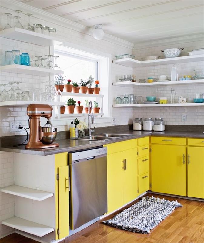 نموذج مطبخ زاوية مع خزانة مطبخ صفراء وسطح عمل رمادي أنثراسايت ، خلفية بيضاء من البلاط ، أرفف بيضاء مع الأواني الفخارية المكشوفة ، طراز عتيق
