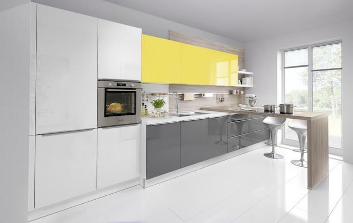 lågt köksskåp i grått, höga köksskåp i gult och vitt, golvplattor i vitt