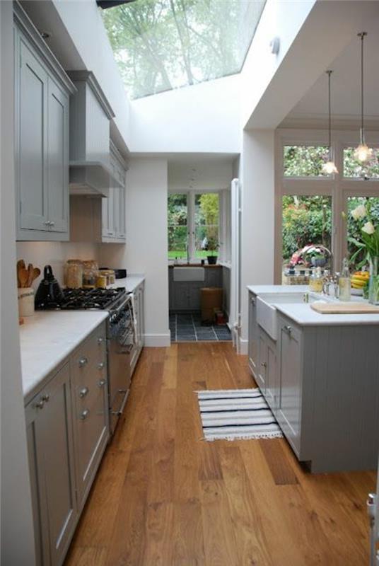kök-med-glasstak-på-taket-ljus-trä-golv-möbler-i-modernt kök