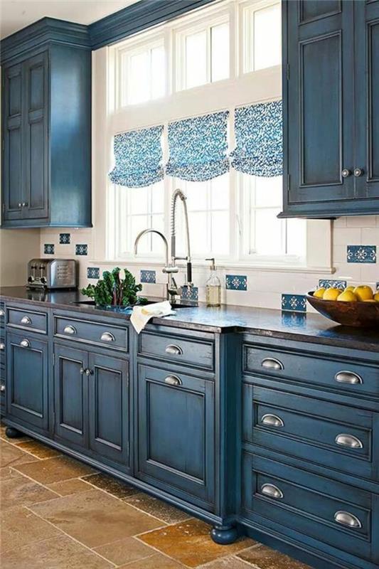 modrá kuchyňa, kačacia modrá skrinka, modro -biele závesy, biele rámy okien, béžové a svetlohnedé obklady, klasický štýl zariaďovania