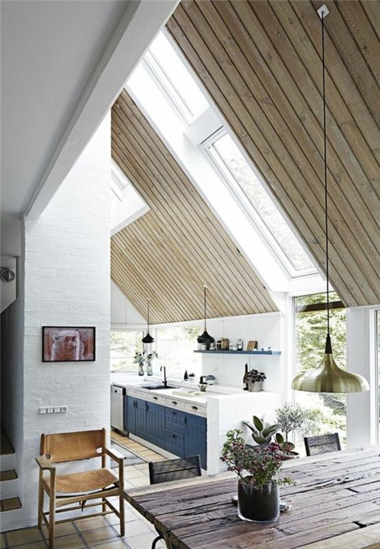 kačací modrý a biely nábytok kačacia modrá kuchyňa pod odkvapom, svetlé a sivé drevené trámy, obdĺžnikový stôl z hrubého hnedého dreva