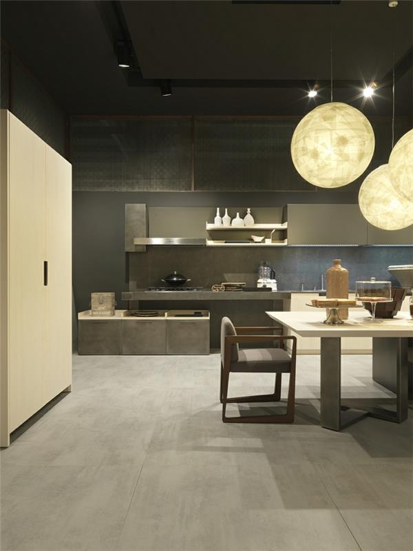 okrúhle glóbusy závesné svetlá, kuchyňa sivá v uhoľnom prevedení, dlhý stôl, stolička v šedej a drevenej farbe, kuchyňa v priemyselnom dizajne